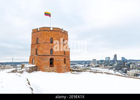 Gediminas Turm oder Burg, der Rest des Obermittelalterlichen Schlosses in Vilnius, Litauen mit litauischer Flagge und Stadt im Winter mit Schnee Stockfoto