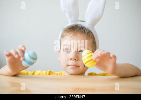 Portrait von lächelnden Jungen mit Hasen Ohren halten farbige Eier für Ostern in Kunststudio, Kopierer Raum. Vorbereitung auf Ostern. Stockfoto