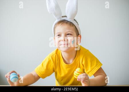 Portrait von lächelnden Jungen mit Hasen Ohren halten farbige Eier für Ostern in Kunststudio, Kopierer Raum. Vorbereitung auf Ostern. Stockfoto