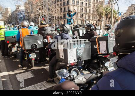 Barcelona, Katalonien, Spanien. Februar 2021, 4th. Hunderte von Lieferern von verschiedenen Plattformen wie Deliveroo, Uber Eats, Glovo, Stuart und auch von Amazon oder Seur haben Barcelona besucht und hupten ihre Autos, Motorräder und Fahrräder an diesem Donnerstag, den 4. Februar, sowie verschiedene Städte in ganz Spanien, In einer Demonstration gegen die Verabschiedung des neuen Rider-Gesetzes, das darauf abzielt, die Situation dieser Arbeiter zu regulieren und die Figur der falschen Selbstständigen verschwinden zu lassen. Stockfoto