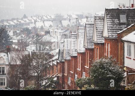 Reihe von identischen englischen Reihenhäusern bedeckt von Schnee in Crouch End, North London, da die Hauptstadt eine seltene Schneedecke erlebt Stockfoto