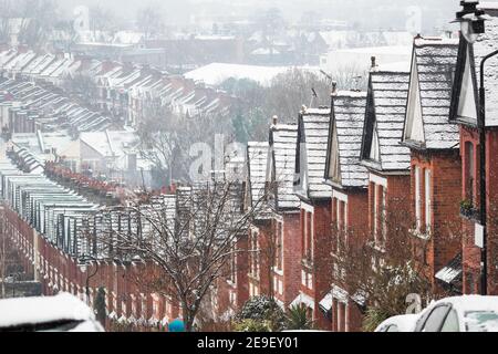 Reihe von identischen englischen Reihenhäusern bedeckt von Schnee in Crouch End, North London als Hauptstadt erlebt eine seltene Abdeckung von Schnee Stockfoto
