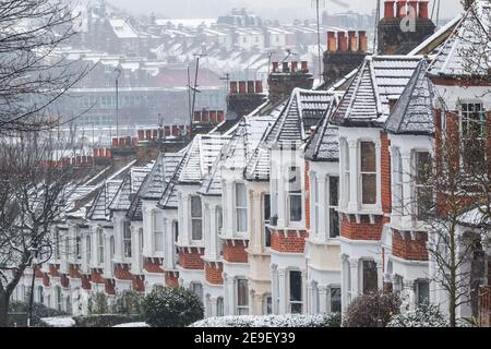 Reihe von identischen englischen Reihenhäusern bedeckt von Schnee in Crouch End, North London, da die Hauptstadt eine seltene Schneedecke erlebt Stockfoto
