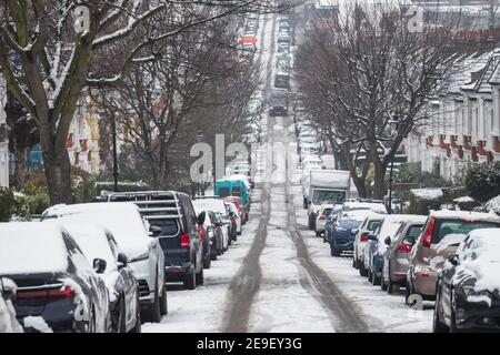 Lange Reihe von Autos geparkt von Schnee auf London bedeckt Straße um Crouch End Bereich als die Hauptstadt erlebt ein Seltene Schneedecke Stockfoto