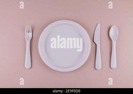 Set aus Kunststoff Geschirr Löffel Gabel Messer graue Platte auf Die Tabelle Stockfoto