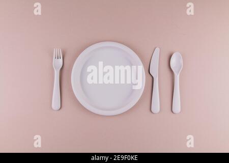 Set aus Kunststoff Geschirr Löffel Gabel Messer graue Platte auf Die Tabelle Stockfoto