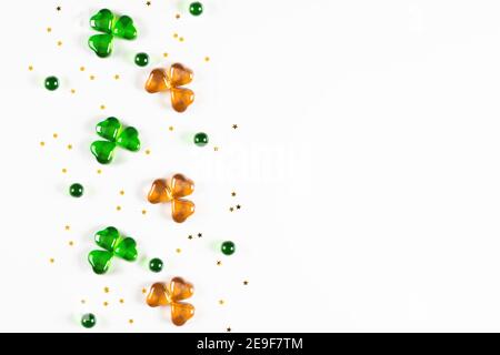 Shamrock Symbole aus grünem und orangefarbenem Glas Herzen auf Weißer Hintergrund Stockfoto