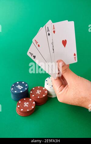 Stapel von Chips und Hand mit vier Assen, Poker Tuch, ein Kartenspiel, Poker Hand und Chips. Hintergrund. Stockfoto
