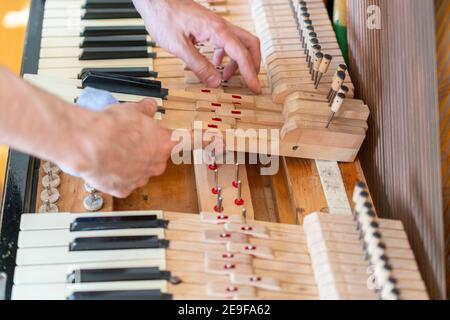 Ein altes Klavier aufsetzen. Der Meister repariert ein altes Klavier. Tiefes Reinigen des Klaviers. Hände von professionellen Arbeiter Reparatur und Tuning eines alten Klaviers Stockfoto