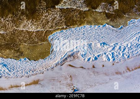 Luftaufnahme über teilweise gefrorenes Meer mit weißer Eisstruktur Stockfoto
