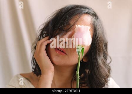 Elegante Frau Studio-Porträt mit weißen rosa und weißen zarten Kleid und natürlichen Look aus nächster Nähe. Geschlossene Augen. Pastellfarben. Zuversichtlich Weiblichkeit. S Stockfoto