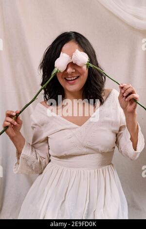 Elegante Frau Studio Porträt mit weißem Kleid und weißen zarten Kleid und natürlichen Look aus nächster Nähe. Stoff Hintergrund. Lächelnd und Spaß haben Stockfoto
