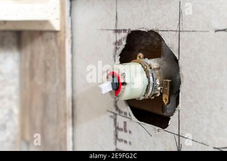 Installation von Dusche Wasserhahn während einer häuslichen Umgestaltung einer gefliesten Dusche in einem Wohn-Badezimmer. Stockfoto