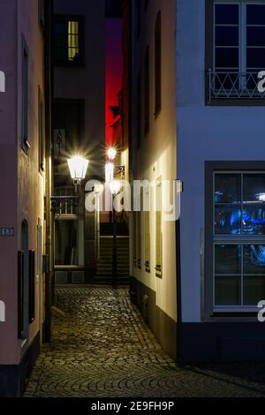 KÖLN, DEUTSCHLAND - 31. Jan 2021: Eine kleine und schmale gepflasterte und beleuchtete Gasse in der Altstadt von Köln bei Nacht Stockfoto