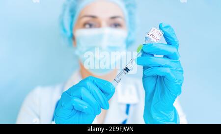 Banner zur Impfung gegen Coronaviren. Ein attraktiver Arzt zieht den Coronavirus-Impfstoff zur Injektion in eine Spritze. Impfung und Immunizati Stockfoto