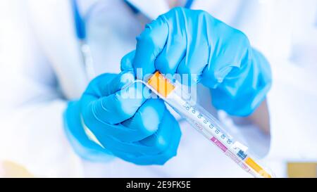 Ein Arzt in blauen Handschuhen öffnet eine Packung mit einer Insulinspritze aus der Nähe. Medizinische Behandlung von Insulin-abhängigem Diabetes mellitus. Die Verwendung von disposa Stockfoto