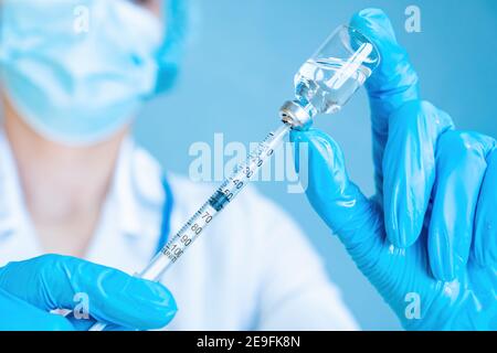 Eine Ärztin zieht Medizin aus einer Medikamentenflasche in eine Insulinspritze. Behandlung von Diabetes mellitus mit Insulinabhängigkeit. Impfung aga Stockfoto