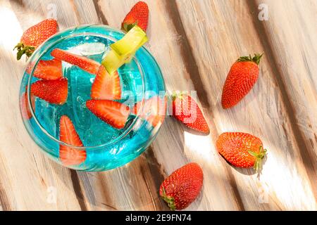 Nahaufnahme eines blauen Getränks mit Erdbeeren in einem serviert Glasfischbehälter Stockfoto