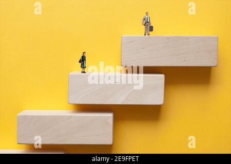 Miniatur Frau und Mann stehen auf Holztreppen auf verschiedenen Ebenen Stockfoto