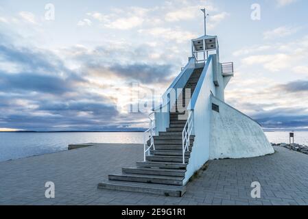 Leuchtturm in Nallikari, Oulu, Finnland. Malerische Abendhimmelkulisse über der tiefblauen Ostsee mit atemberaubenden Wolken bei Sonnenuntergang. Schöne Treppen zu observati Stockfoto