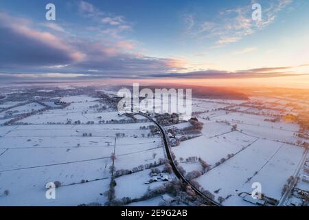 Sonnenaufgang in Wiesmoor, Eastfrisa an einem kalten Wintermorgen mit Schnee und einem bunten Sonnenaufgang. Stockfoto