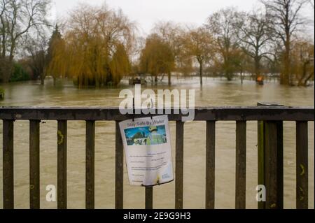 Sonning, Berkshire, Großbritannien. 4th. Februar 2021. Ein Schild "Stay Safe by Water" mit Blick auf das überflutete Gelände des French Horn in Sonning. Nach heftigen Regenfällen in den letzten Tagen ist die Themse am Sonning in Berkshire in die Ufer geplatzt. Ein Hochwasser-Warnhinweis ist vorhanden und tief liegende Straßen, Wege und Felder sind überflutet. Obwohl die B478 über die Sonning-Brücke wegen der Überschwemmungen geschlossen ist, ignorierten einige Fahrer die Straßensperrschilder und fuhren durch die Überschwemmungen. Quelle: Maureen McLean/Alamy Stockfoto