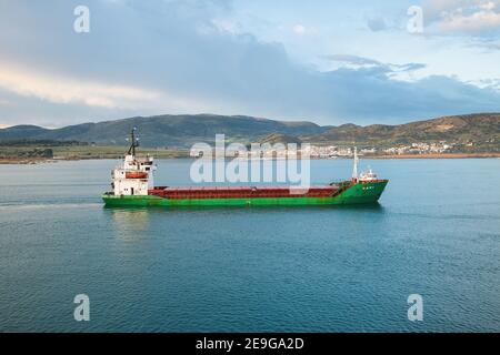 VOLOS, GRIECHENLAND - 30. Jan 2021: Handelsschiff mit Hilfe eines Schleppschiffes fährt in den Hafen von Volos ein Stockfoto