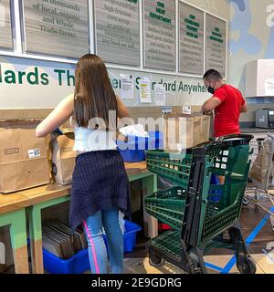 Orlando, FL USA - 24. Januar 2021: Amazon Prime Fresh Mitarbeiter überprüfen und Absacken ihrer Bestellungen in einem Whole Foods Lebensmittelgeschäft. Stockfoto