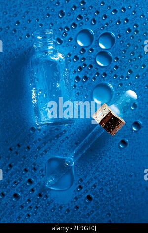 Blaues Wasser Hintergrund mit Glas Kosmetik Flasche und Medikament Tropf. Feuchtigkeitsspendende flache legen. Stockfoto