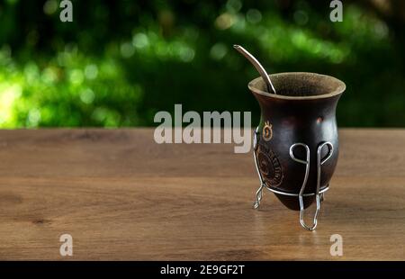 Traditionelle Mate aus Kalabash über einem Holztisch im Freien. Speicherplatz kopieren. Kultur südamerikas. Stockfoto