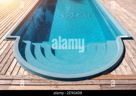 Neue moderne Fiberglas Kunststoff Schwimmbad Eingang Schritt mit sauber Frisches, erfrischendes blaues Wasser an einem heißen Sommertag Hof oder Resort Hotel Spa Stockfoto