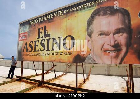 Ein Polizist steht neben einer riesigen Plakatwand, auf der der Spielfilm 'El Asesino' (der Mörder) mit US-Präsident George W. Bush, dargestellt als Vampir, Und der Anti-Castro-Flüchtling Luis Posada Carriles in Havanna, Kuba, am 5. August 2006, fünf Tage nachdem Fidel Castro seinem Bruder Raul die provisorische Kontrolle über die Regierung übergab, die er seit 47 Jahren ununterbrochen geführt hat. Die kubanischen Bürger warten darauf, herauszufinden, ob der 'Lider Maximo' nach seiner Genesung von einer Darmoperation wieder die Führung übernehmen wird. Foto von ABACAPRESS.COM Stockfoto