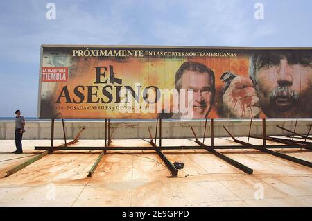 Ein Polizist steht neben einer riesigen Plakatwand, auf der der Spielfilm 'El Asesino' (der Mörder) mit US-Präsident George W. Bush, dargestellt als Vampir, Und der Anti-Castro-Flüchtling Luis Posada Carriles in Havanna, Kuba, am 5. August 2006, fünf Tage nachdem Fidel Castro seinem Bruder Raul die provisorische Kontrolle über die Regierung übergab, die er seit 47 Jahren ununterbrochen geführt hat. Die kubanischen Bürger warten darauf, herauszufinden, ob der 'Lider Maximo' nach seiner Genesung von einer Darmoperation wieder die Führung übernehmen wird. Foto von ABACAPRESS.COM Stockfoto