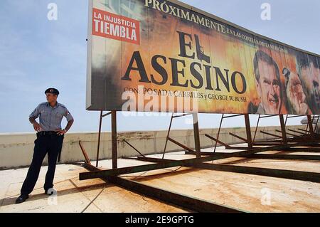 Ein Polizist steht neben einer riesigen Plakatwand, auf der der Spielfilm 'El Asesino' (der Mörder) mit US-Präsident George W. Bush, dargestellt als Vampir, Und der Anti-Castro-Flüchtling Luis Posada Carriles in Havanna, Kuba, am 5. August 2006, fünf Tage nachdem Fidel Castro seinem Bruder Raul die provisorische Kontrolle über die Regierung übergab, die er seit 47 Jahren ununterbrochen geführt hat. Die kubanischen Bürger warten darauf, herauszufinden, ob der 'Lider Maximo' nach seiner Genesung von einer Darmoperation wieder die Führung übernehmen wird. Foto von ABACAPRESS.COM Stockfoto