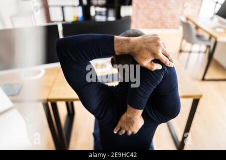 African Employee Man Doing Wellness Fitness Gesundheit Stretch Am Schreibtisch Stockfoto