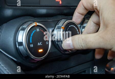 Mit Klimaanlage in einem Auto, Nahaufnahme. Die Hand manipuliert den Lüftungsregler im Fahrzeug. Stockfoto