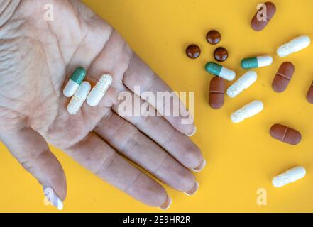 Weibliche Hand hält Vitamine und Pillen Stockfoto