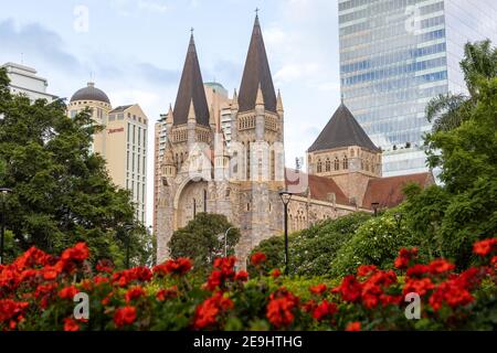 Saint Johns Cathedral Church mit roten Blumen selektiv verschwommen in Brisbane City Queensland am 31st 2021. Januar Stockfoto