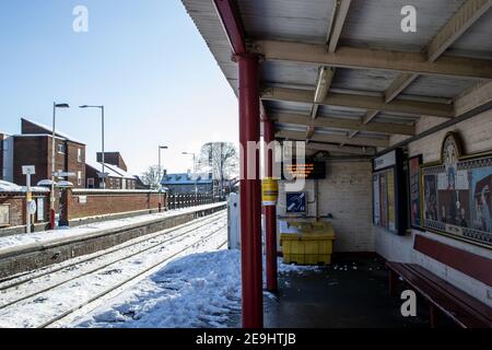 OAKHAM, RUTLAND, ENGLAND- 25. JANUAR 2021: Bahnsteig am Bahnhof Oakham an einem verschneiten Tag Stockfoto