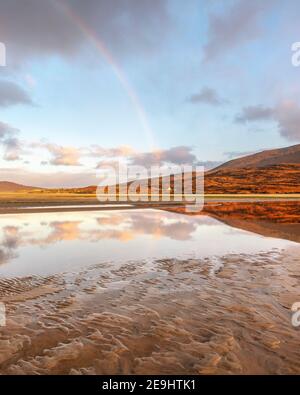 Isle of Lewis and Harris, Schottland: Ein Regenbogen und die weitläufige Sandbucht von Luskentire Beach auf South Harris Island Stockfoto