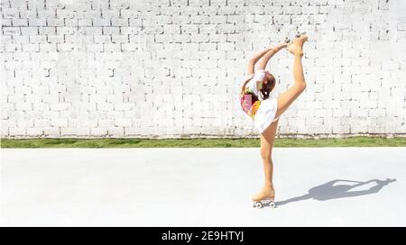 Teenager-Mädchen in eleganten Kostüm üben Eiskunstlauf auf vier Rädern. Üben Sie den Korb oder Diamant Stockfoto