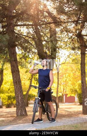 Männlicher Radfahrer Trinkwasser im Freien Stockfoto