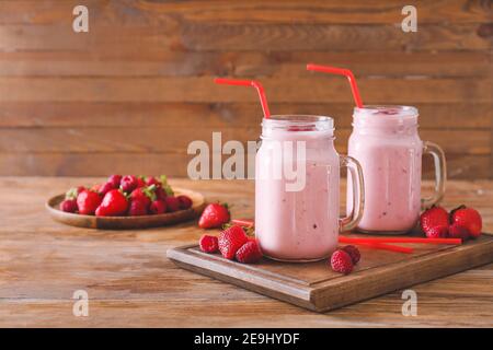 Mason Gläser von köstlichen Smoothie mit Erdbeere und Himbeere auf Holzhintergrund Stockfoto