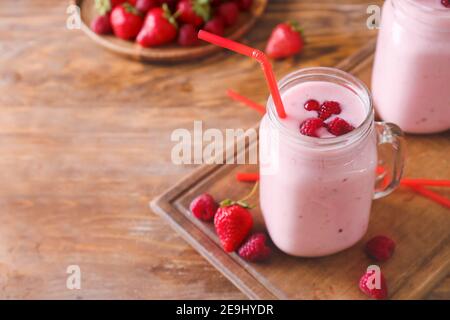 Mason Glas von köstlichen Smoothie mit Erdbeere und Himbeere auf Holzhintergrund Stockfoto