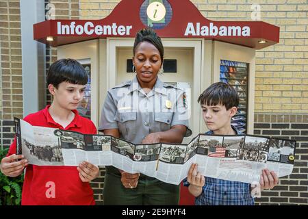 Alabama Scenic Highway 80 Selma nach Montgomery Civil Rights Trail, Lowndes Interpretive Center Center Zentrum Schwarze Frau weibliche Park Ranger, Jungen suchen Ordner Stockfoto