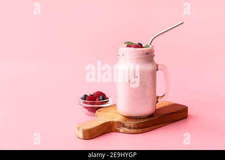 Mason Glas von leckeren Smoothie mit Himbeere und Heidelbeere auf Farbiger Hintergrund Stockfoto