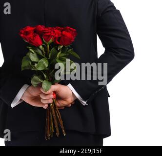 Schöner Mann mit Blumenstrauß hinter seinem Rücken Auf weißem Hintergrund Stockfoto