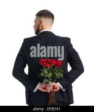 Schöner Mann mit Blumenstrauß hinter seinem Rücken Auf weißem Hintergrund Stockfoto