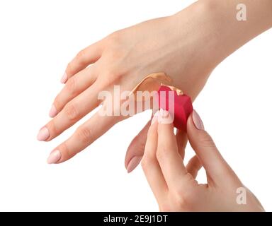 Hände mit Make-up Schwamm und Probe Concealer auf weiß Hintergrund Stockfoto