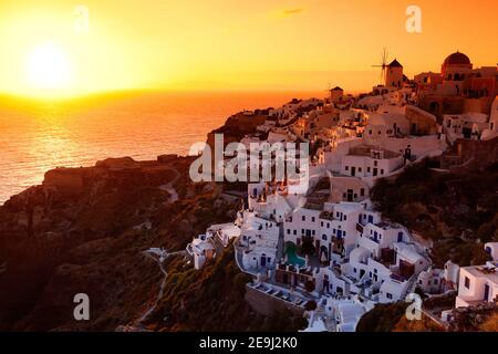 Santorini, Griechenland der Sonnenuntergang in der Klippe Oia mit seinen traditionellen weiß getünchten Stuckhäusern. Stockfoto